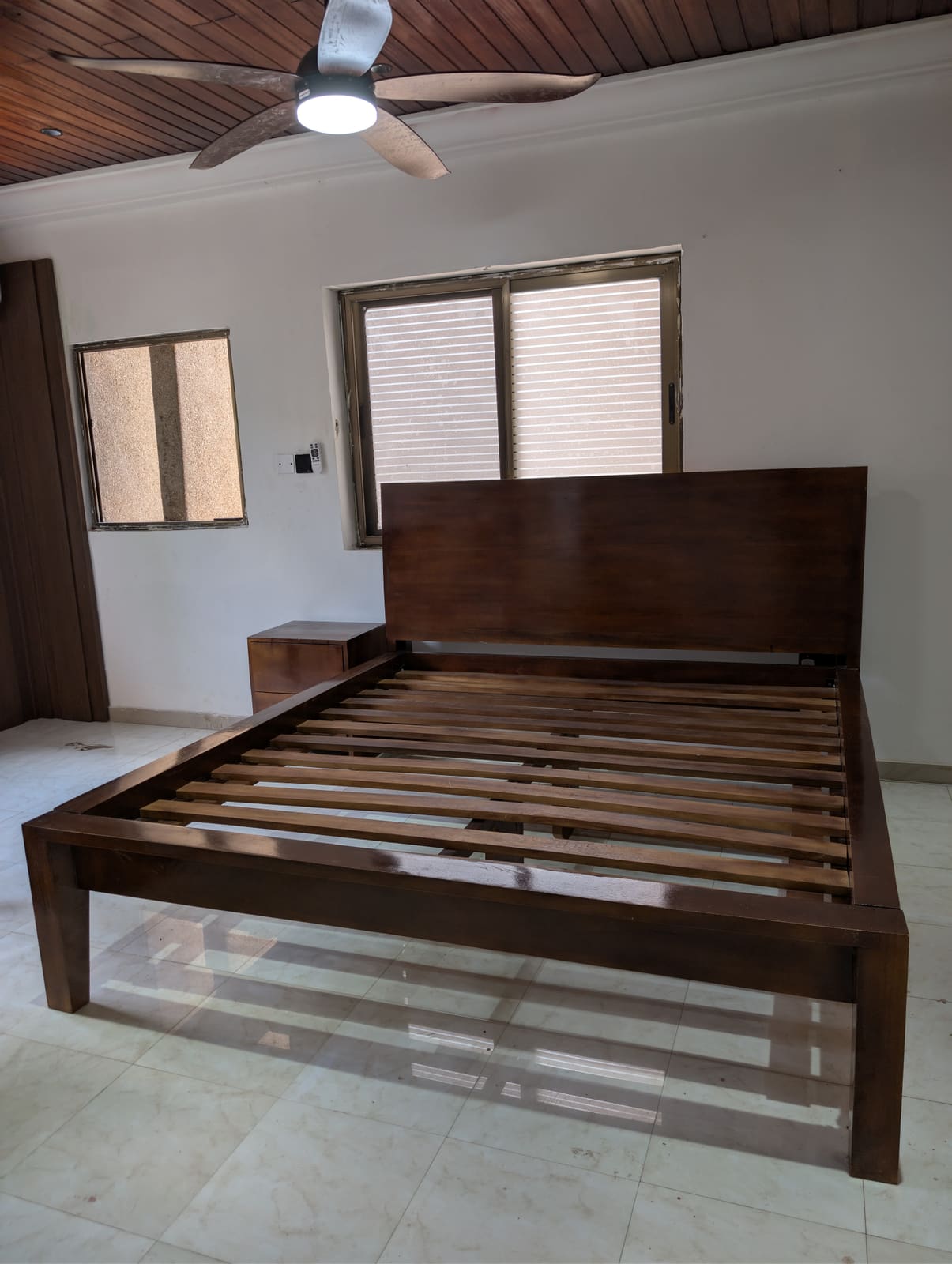 Custom solid wood queen bed frame with panelled headboard and matching nightstand, Achimota guesthouse