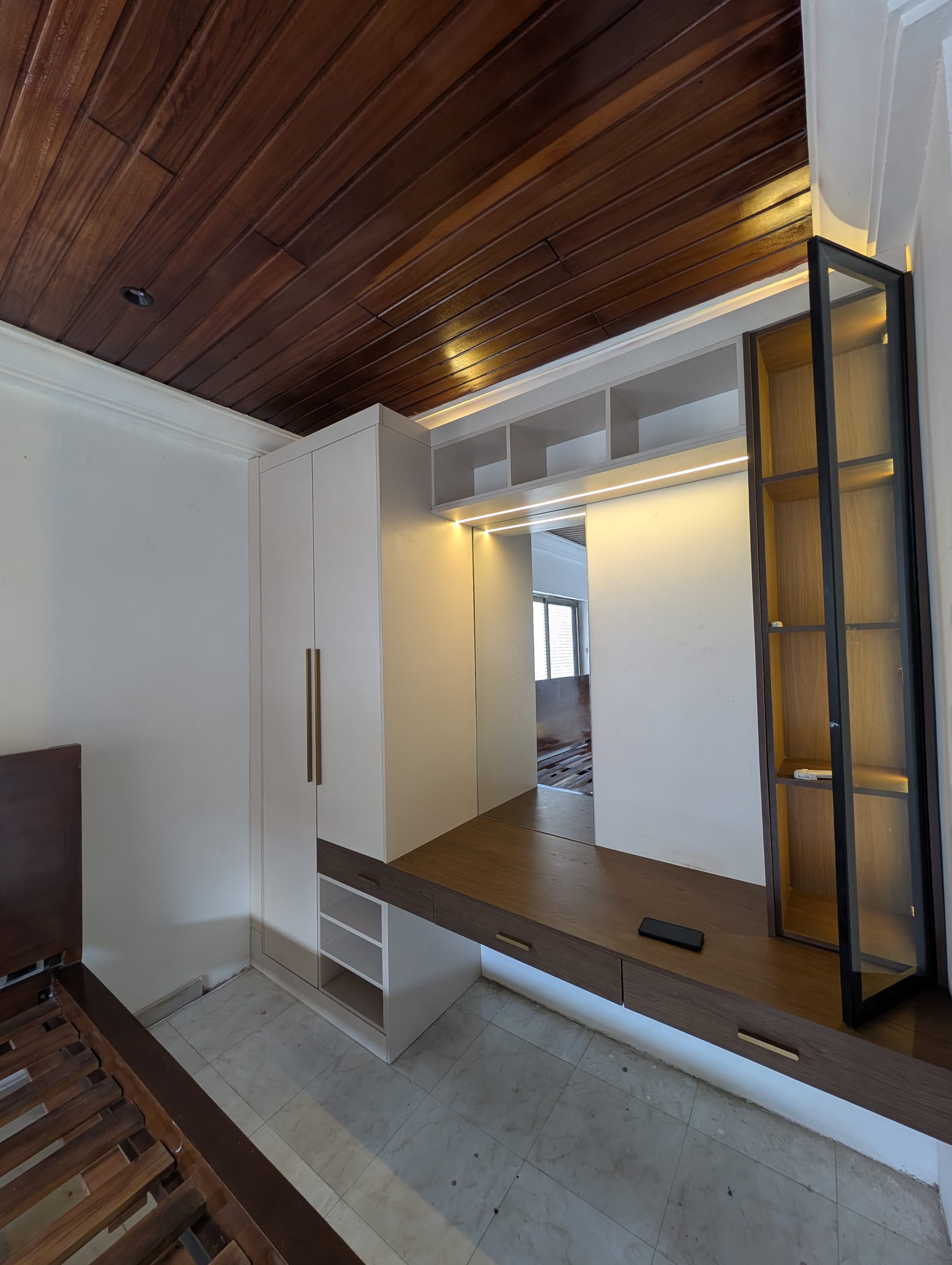 Achimota guesthouse room conversion — wardrobe, vanity, and lit glass display cabinet, Accra