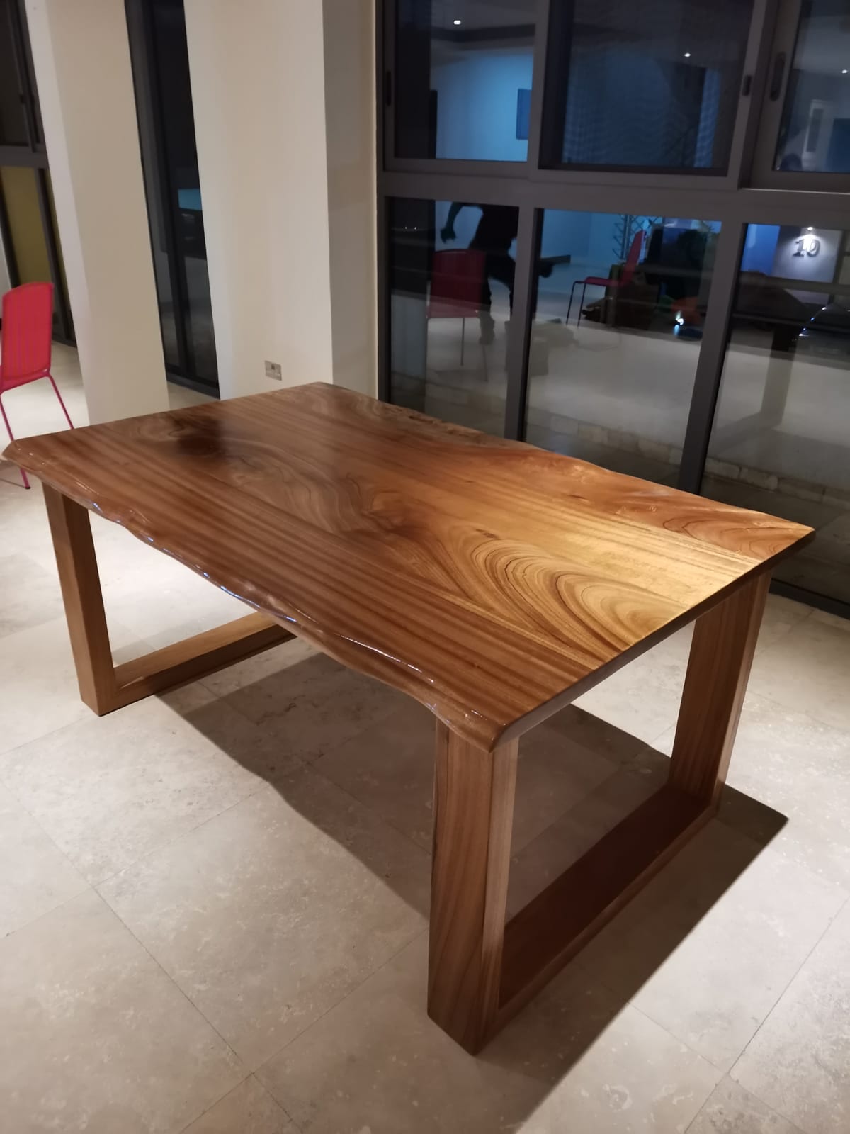 Afromosia live-edge dining table installed — evening view