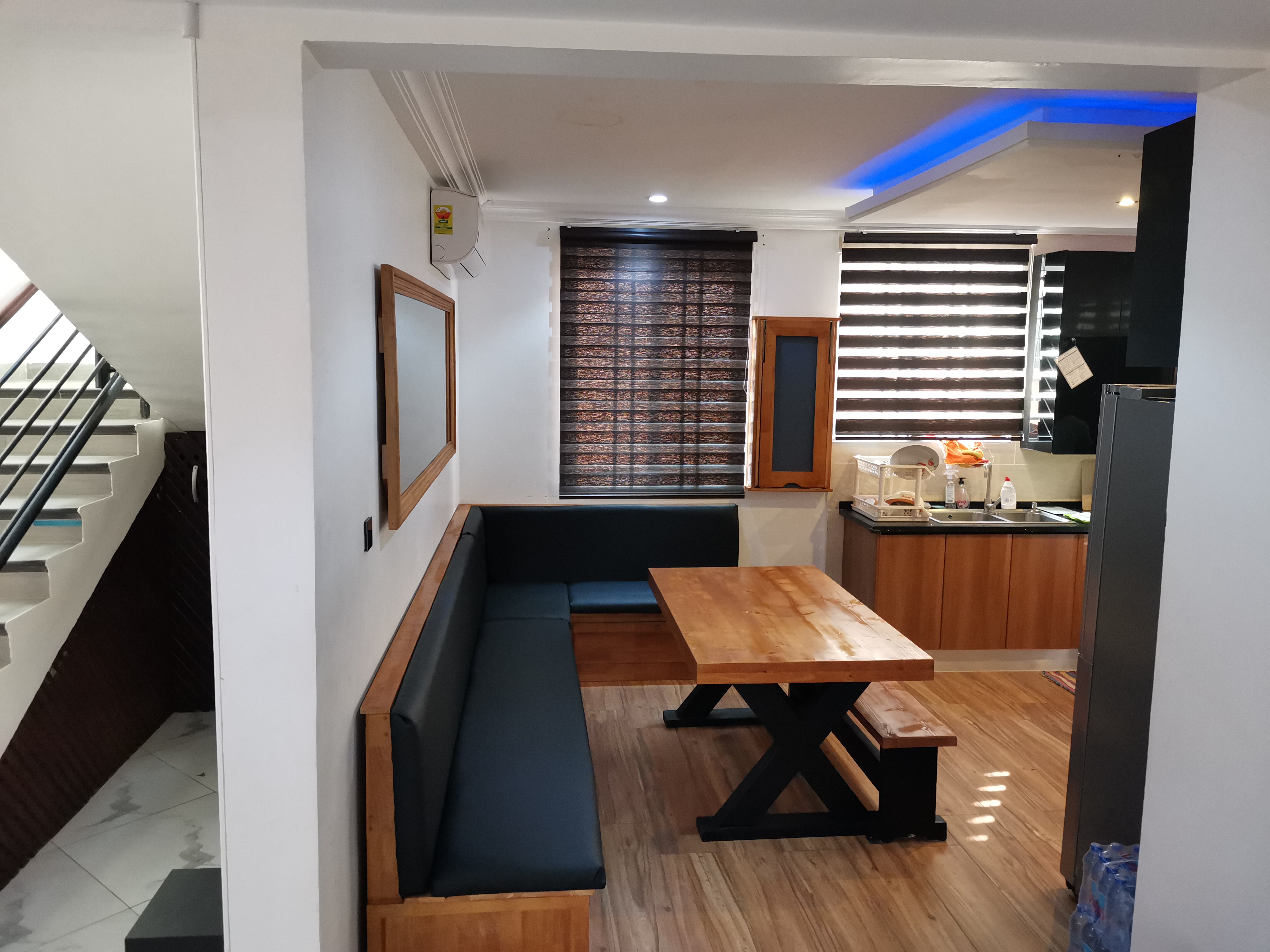 X-frame pine dining set and built-in banquette — Golf Hills Estate, Accra