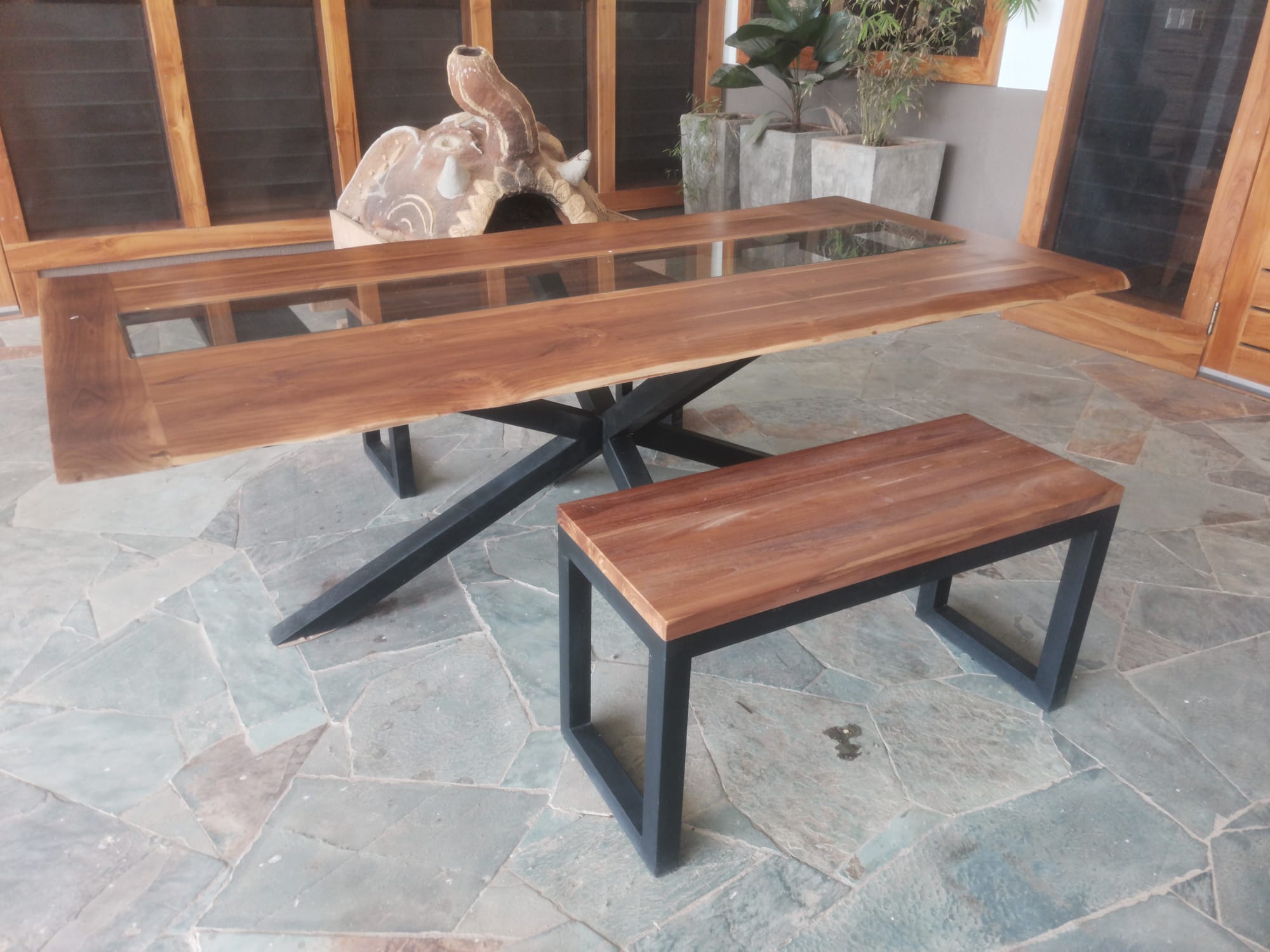 Outdoor upholstered sofa with live-edge coffee table on a slate patio
