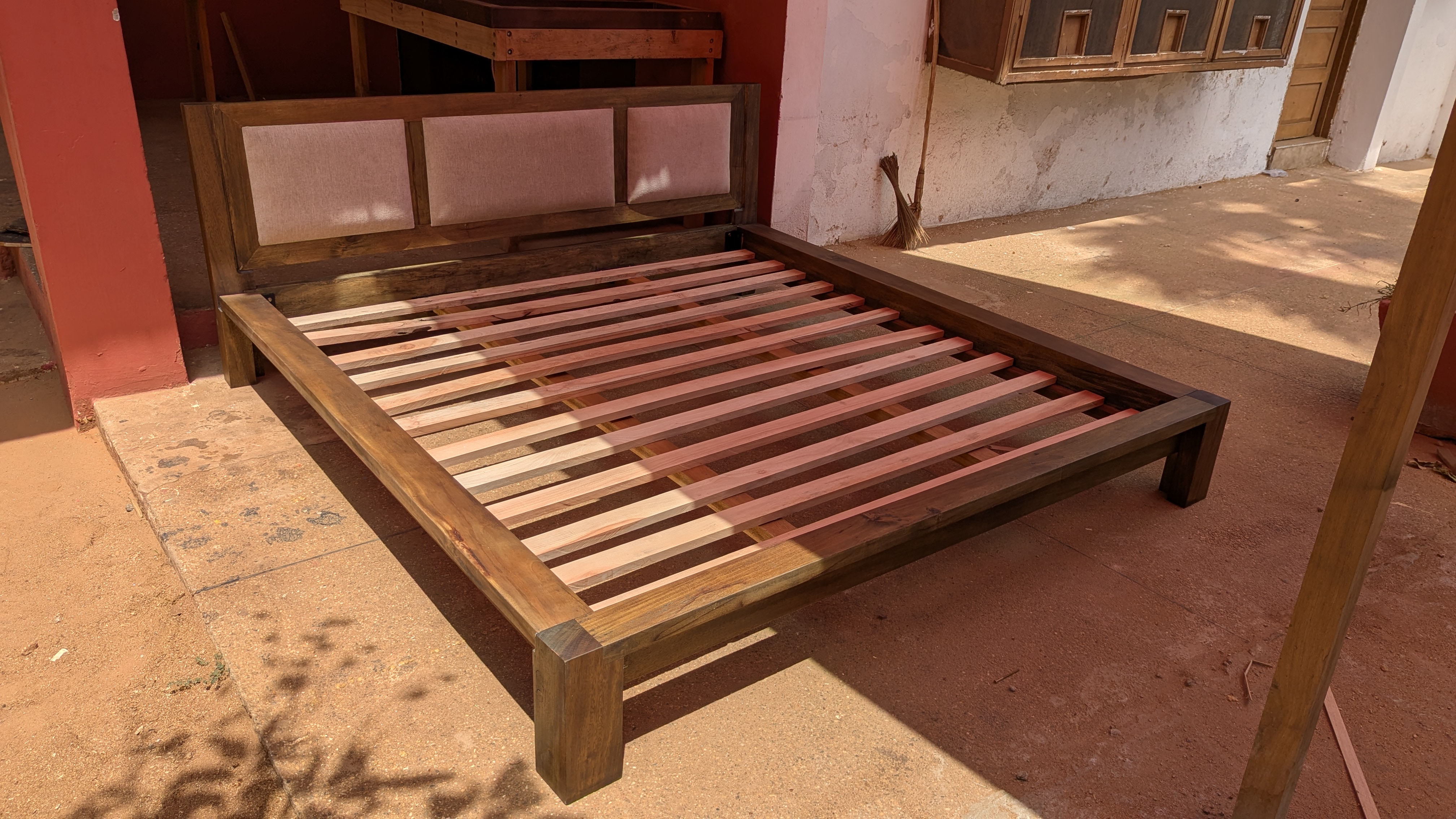 Custom platform bed in dark walnut stain with upholstered linen headboard panels, Accra