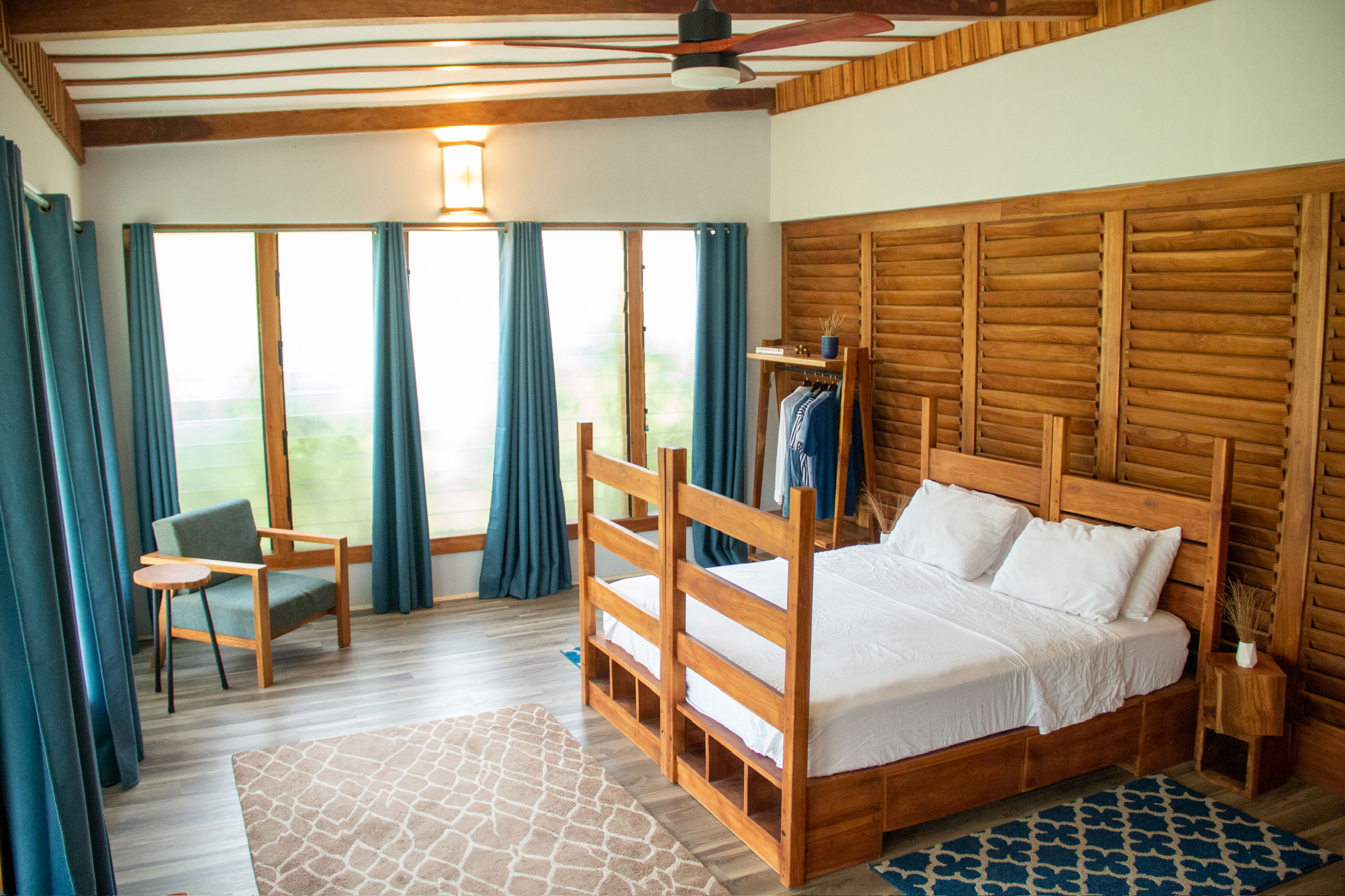 Custom teak bed frame with louvre wall headboard and solid teak garment rack, Sage Centre, Wli, Volta Region
