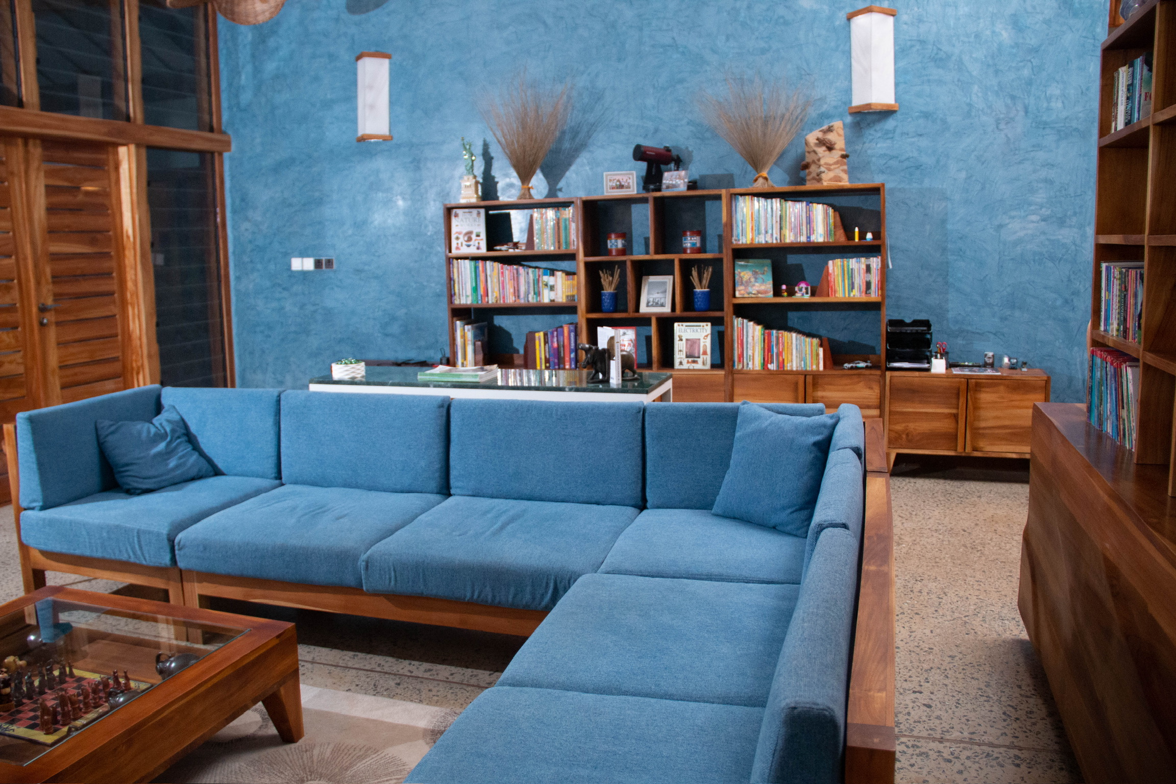 Evening interior of Sage Centre living room with blue teak sofa