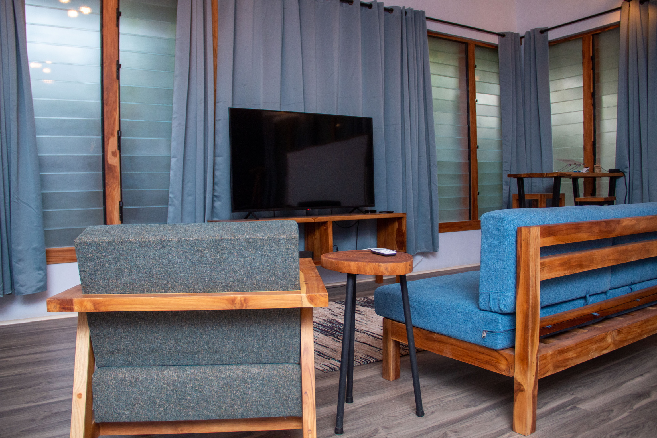 Teak sofa lounge with TV unit in Sage Centre guest room